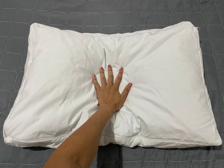 imagem de uma mão afundando o travesseiro